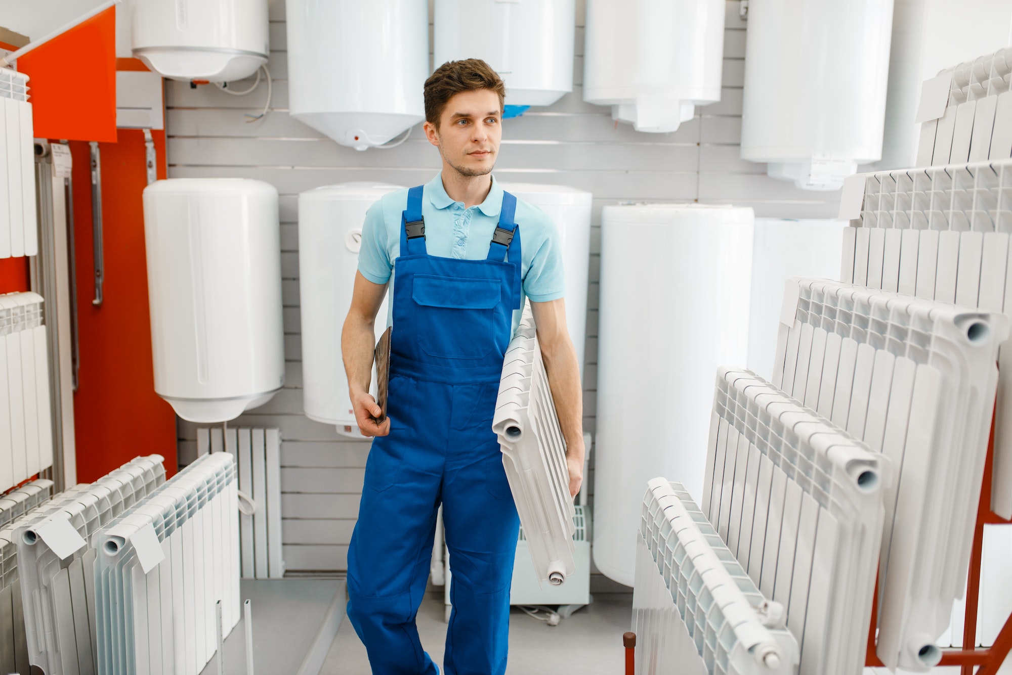 Plumber holds heating radiator, plumbering store