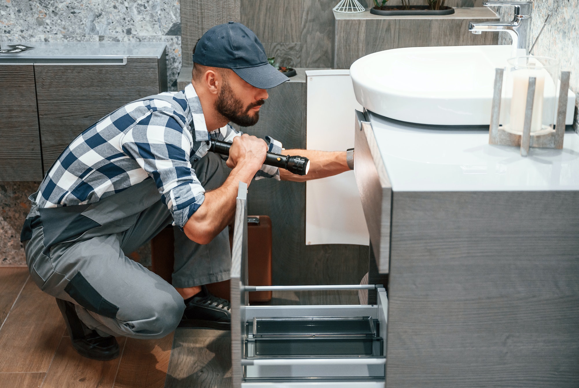 Plumber in uniform is working indoors